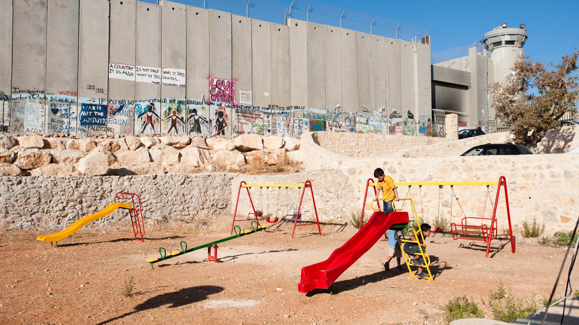Palestinian child playing on a slide.
