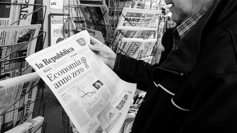 Man holding a copy of La Repubblica newspaper
