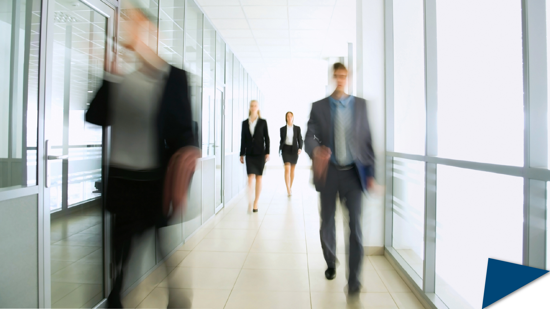 Blurry people walking in an office.